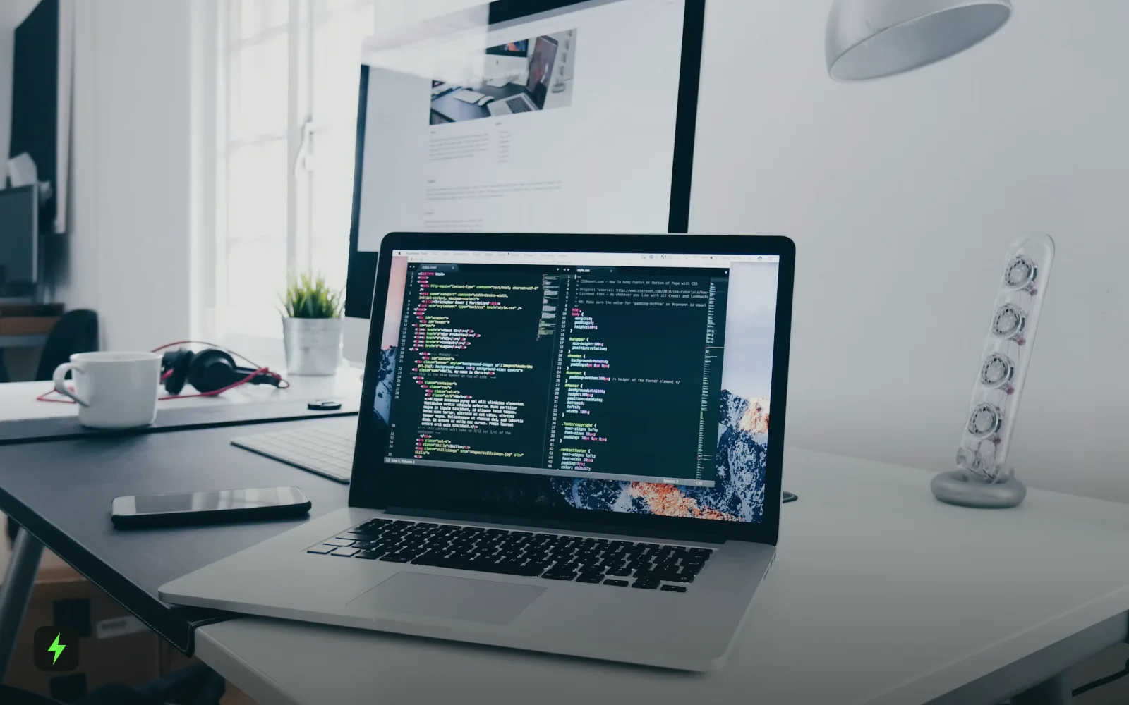 A laptop showing code on a busy desk